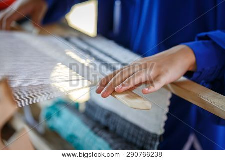 Hands Of Woman Weaving Fabric On A Wooden Loom. Traditional Russian Folk Art