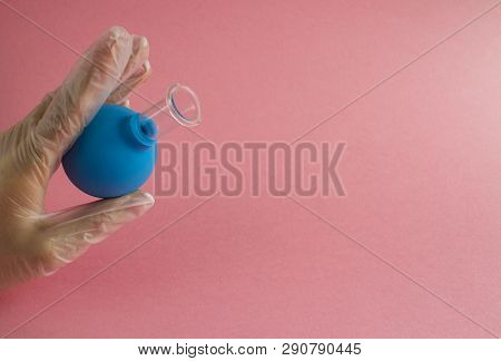 Female Hand With French Manicure In Medicine Glove Holds Blue Cosmetic Medical Jar For Vacuum Facial