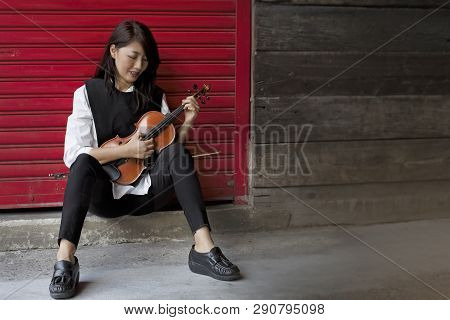 In Selective Focus Of  Beauty Lady Wearing Wihte Shirt And Black Jeans,use Finger To Plucking The St