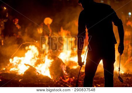 Silhouette Of People In Front Of Fire Roasting Grain For Holi Lohri Festival