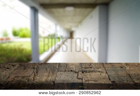 Wooden Brown Table Top Against The Blurred Corridor, Passage And Courtyard Of The House .for Product
