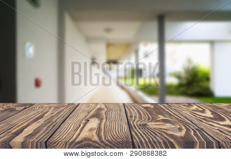 Wooden Brown Table Top Against The Blurred Corridor, Passage And Courtyard Of The House .for Product