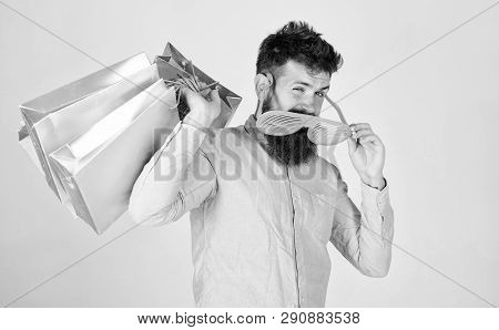 How To Get Ready For Your Next Vacation. Man Bearded Hipster Wear Sunglasses Hold Bunch Shopping Bag