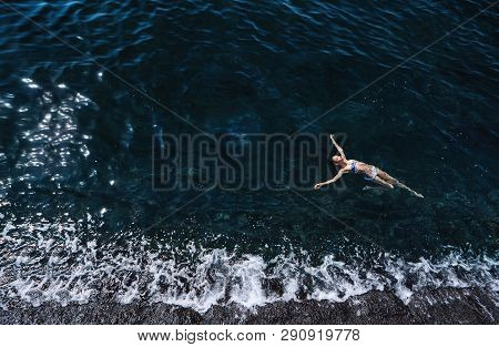Aerial View Of A Woman Floating And Reraxing In The Sea