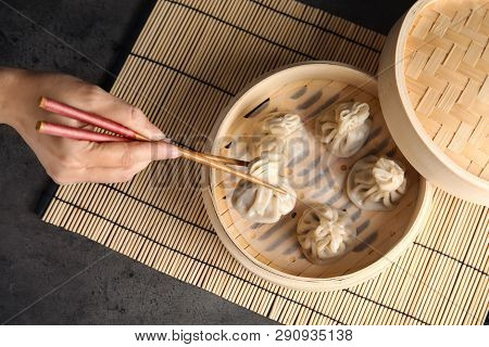 Woman Cooking Tasty Baozi Dumplings In Bamboo Steamer At Table, Top View