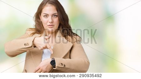 Beautiful plus size young woman wearing winter coat over isolated background In hurry pointing to watch time, impatience, upset and angry for deadline delay