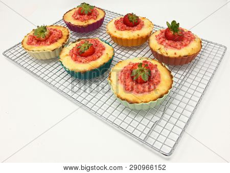 Keto Strawberry Cheesecake Tarts in silicone cups on a metal cooling rack.