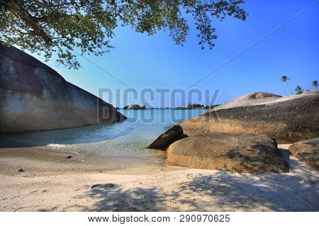 Scenic View Of Belitung Island Beach With Bigrock And Tree Leaves As Foreground