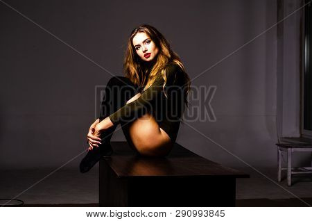 Beautiful Dancer. Girl Model. The Girl Sits In A Hat And Sits On A Table. Girl In A Beautiful Underw
