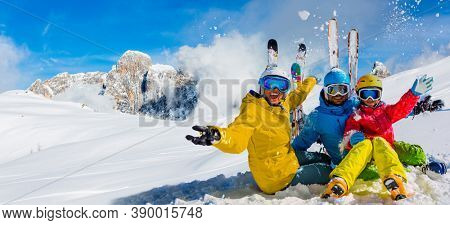 Skiing family enjoying winter vacation on snow in sunny cold day in mountains and fun. San Martino di Castrozza, Italy.