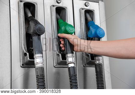 Pistols With Gasoline At The Gas Station. Hand Holds A Pistol.