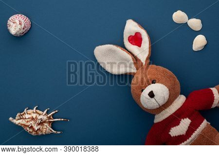 Plush Rabbit On A Blue Background With Seashells