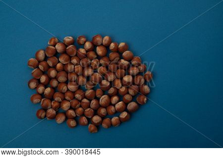 Many Nuts Lie In One Pile On A Blue Background