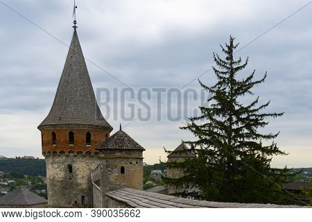 Sceneric View At Tower Of Medieval Stone Castle At Kamenets Podolskiy, Green Tree, Cloudy Blue Sky.