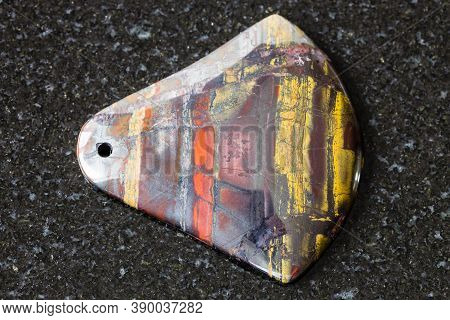 Pendant From Jaspillite (jaspilite) Gemstone On Black Granite Background