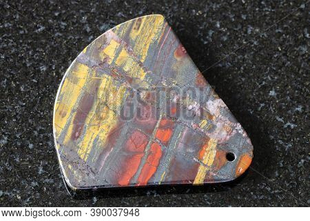 Pendant From Polished Jaspillite (jaspilite) Stone On Black Granite Background