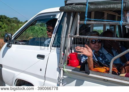 Chaung Thar, Myanmar - December 26, 2019: An Older Unidentified Woman In Sunglasses Waves From The B