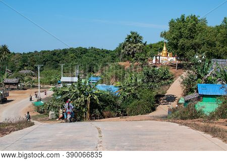 Chaung Thar, Myanmar - December 26, 2019: People Drives Motorbikes Through A Rural Society On An Asp