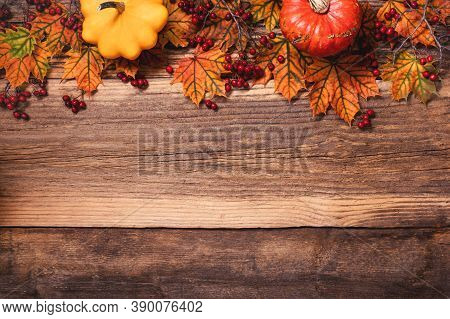 Autumn Leaves With Dogberry And Colorful Pumpkins Over A Textured Vintage Rustic Wooden Background W