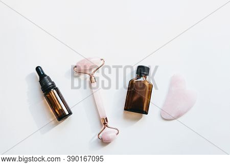 Facial Massage Roller, Guasha And Face Serum On White Background. Skin Care Products.