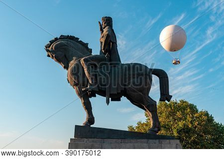 Statue Of King Vakhtang Gorgasali In Tbilisi, Air Excursion Balloon For Passengers Against The Blue