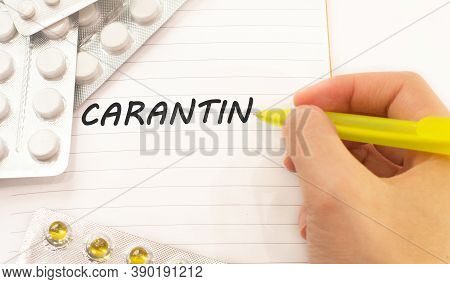 Word Carantin Written On A White Piece Of Paper. Pills And Vitamins Lie Nearby