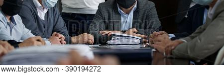 Officials Or Businessmen Sit At A Table Next To A Plethora Of Paper Documents At A Business Meeting 