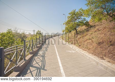 Walking Path With Bikeway And Fence Goes Up The Hill In The Park