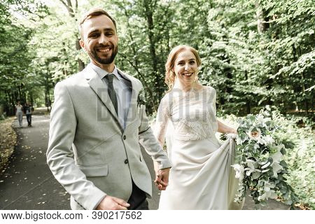 Just Married Couple Dancing Valse Outdoors, Free Space. Bride And Groom Hug, Blurred Green Grass Bac