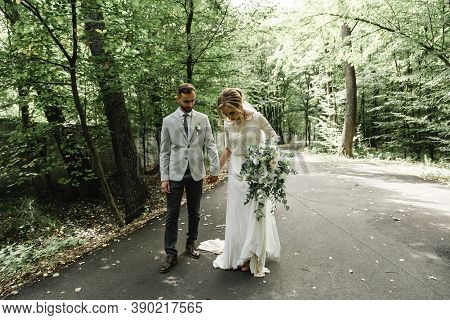 Just Married Couple Dancing Valse Outdoors, Free Space. Bride And Groom Hug, Blurred Green Grass Bac
