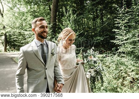 Just Married Couple Dancing Valse Outdoors, Free Space. Bride And Groom Hug, Blurred Green Grass Bac