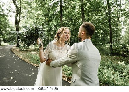 Just Married Couple Dancing Valse Outdoors, Free Space. Bride And Groom Hug, Blurred Green Grass Bac