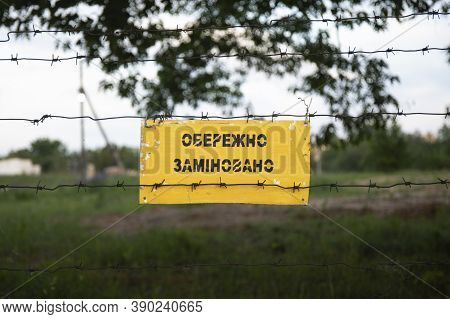 Landmines Sign On Barbed Wires. Translation From Ukrainian - Danger Mines.