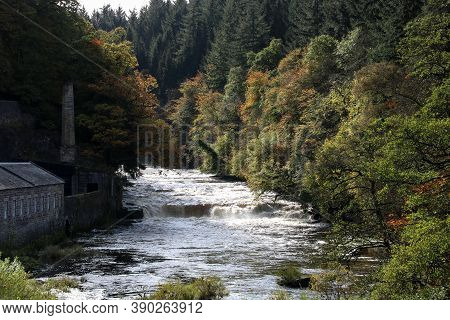 Old Abandoned Textile Mill And Fast Flowing River At New Lanark Scotland In Autumn