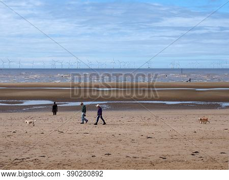 Southport, Merseyside, United Kingdom - 10 September 2020: People Walking On The Beach With Dogs At 