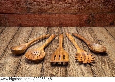 wooden kitchen cooking utensils set on a rustic weathered barn wood background
