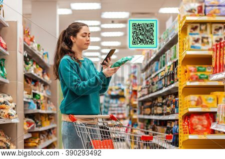 A Young Beautiful Caucasian Woman Reads The Qr Code Information Using Her Smartphone. Qr-code Icon A