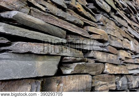 The Stone Wall Made Of Slate Bricks Which Is A Very Rough Material