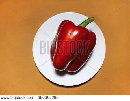 Red Bell Pepper On A White Plate On A Beige Background
