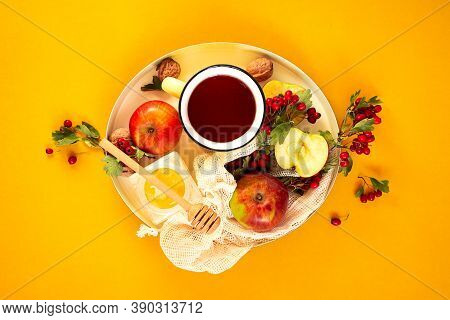 Cozy Autumn Hot Tea With Honey, Apples And Red Hawthorn Berries On A Tray. Still Life On An Orange B