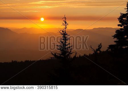 Thick Layers Of Smoke From A Nearby Forest Fire Turn The Suns Rays A Glowing Orange As It Sets Over 