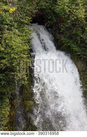The Upper Section Of Mill Creek Falls As It Rushes Out Of Thick Natural Forest Land To Plunge Downwa
