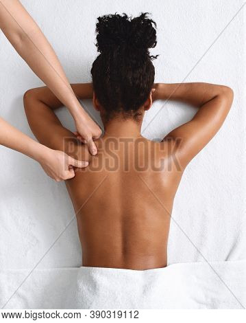 African American Naked Woman Getting Relaxing Back Massage On White, View Above. Top View Of Black L