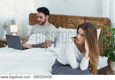 Relationship, Problems, A Lot Of Work And Virtual Treason. Upset Woman Sitting On Bed And Looking At