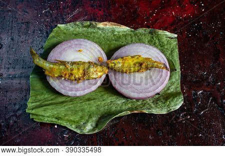 Closeup Of Cooked Mourala Fish Or Indian Carplet Fish On Onion Slices