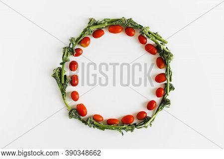 Cherry Tomato And Broccoli Florets Wreath On White Background, Top View. Plant Based Diet Concept