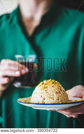 Woman Holding Plate With Turkish Semolina Helva With Pistachio