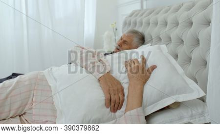 Senior Caucasian Grandparents Couple Lying And Sleeping In Bed At Home. Irritated Woman Getting Dist