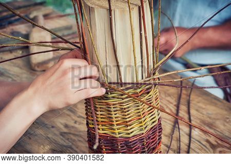 Men Hands Weave Craft Basket Of Tree Branches. Vintage Work Of Artisans Basket-makers In The Old Day