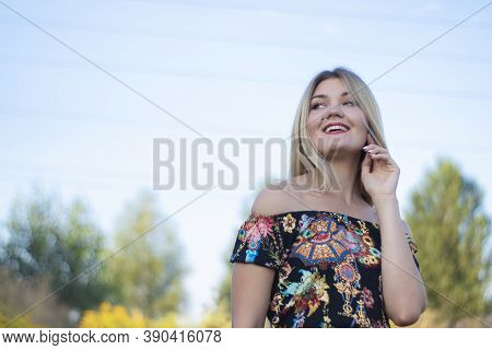 Overlight Bright Portrait Of A Charming Attractive Blonde In Flowery Dress In The Field